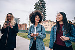 Friends walking in street, Milan, Italy