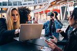 Friends working on virtual reality project at outdoor cafe, Milan, Italy