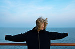 Teenage girl leaning against handrail on windy day