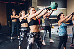 Women training in gym, lifting kettle bells