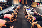 Women training in gym with male trainer, doing push ups