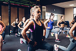 Group of women training in gym, stretching with hands on hips