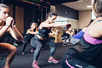 Group of women training in gym, squatting
