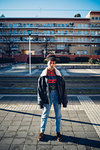 Cool young woman standing on urban sidewalk, portrait