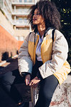 Cool young woman sitting on urban wall