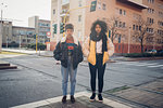 Two cool young women standing by city tramline