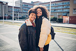 Two young women posing on urban sidewalk, portrait