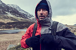 Male hiker with hood up in snow capped mountain landscape, portrait, Llanberis, Gwynedd, Wales