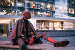 Stylish man sitting on concrete bench, Milan, Italy