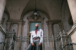 Stylish man standing on steps of period building, Milan, Italy