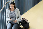 Businesswoman using digital tablet on staircase