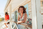 Portrait smiling, confident woman on sunny beach hut patio
