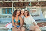 Portrait happy multi-generation women outside sunny beach hut