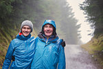 Portrait father and son hiking in rain