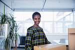 Portrait confident businesswoman moving into new office