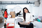 Portrait smiling, confident businesswoman using laptop in new office