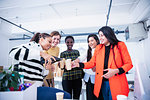 Businesswomen celebrating new office, pouring champagne