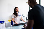 Patient speaking with nurse at hospital reception