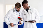 Doctors using smartphone at hospital reception