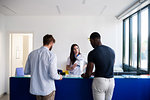 Nurse speaking with patients at hospital reception