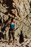 Woman with flippers on beach, rock face in background, Big Sur, California, United States