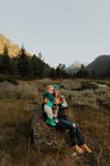 Mother and toddler daughter sitting on boulder in rural valley, portrait, Mineral King, California, USA