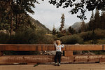 Female toddler looking out at river from rural bridge, rear view, Mineral King, California, USA