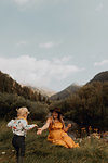 Mother reaching out for toddler daughter's hand in rural valley, Mineral King, California, USA