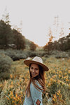 Young woman in stetson looking over her shoulder in rural valley, portrait, Mineral King, California, USA