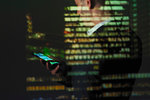 Double exposure businessman using smart phone against highrise at night