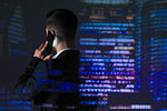 Double exposure businessman talking on smart phone against highrise lights at night