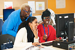 Female professor and college students using computer in computer lab