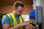 Male electrician student examining light switch in workshop