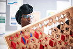 Female artist in dhuku headscarf working in art studio