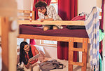 Young female backpackers on bunk bed in youth hostel