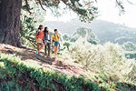 Mother and daughters hiking in sunny woods