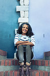 Portrait smiling, confident woman sitting on brick steps