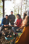 Family cooking around campsite campfire