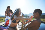 Playful lesbian couple and kids at sunny, summer poolside