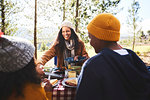 Happy mother and kids eating at campsite