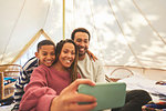 Happy, affectionate family taking selfie in camping yurt