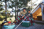 Father and son playing cards outside yurt at campsite