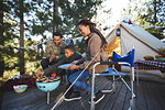 Family cooking vegetables at campsite grill