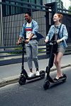 Couple riding push scooters