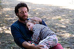 Father and daughter sitting in park