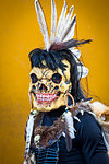 Portrait of an indigenous tribal dancer wearring skeleton mask with feathers at a St Michael Archangel Festival parade in San Miguel de Allende, Mexico