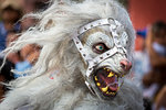 Close-up of a person wearing a white wolf mask at a St Michael Archangel Festival parade in San Miguel de Allende, Mexico