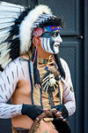 Portrait of a young, male indigenous tribal dancer in face paint and headdress at a St Michael Archangel Festival parade in San Miguel de Allende, Mexico