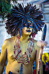 Close-up of a male, indigenous tribal dancer painted in gold and wearing black feather headdress at a St Michael Archangel Festival parade in San Miguel de Allende, Mexico