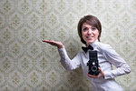 vintage photographer showing some copyspace in her hand in front of a vintage background